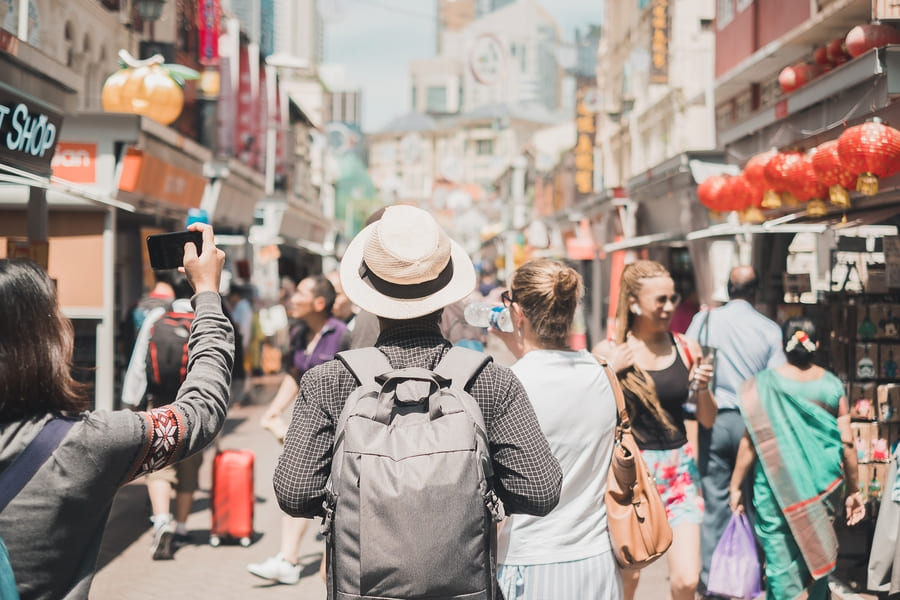 Varias personas paseando por una calle, algunas riendo y otras conversando animadamente en una calle en China